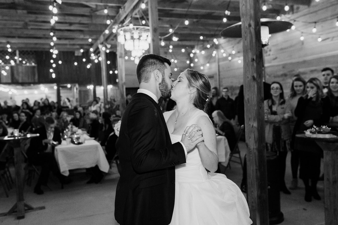 Black & white photo of bride and groom kiss